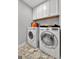 Functional laundry room with white cabinets, marble floor, and modern washer and dryer units offers convenience at 517 Daffodil Ln, Mcdonough, GA 30253
