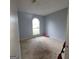 A bedroom with stained carpet and a unique arch window providing natural light at 2884 Haddon Dr, Rex, GA 30273