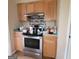 Kitchen featuring stainless steel stove and oven, tile backsplash, and wood cabinetry at 2884 Haddon Dr, Rex, GA 30273