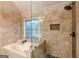 Close up of soaking tub and shower with custom tiled shower and decorative glass window at 7415 Northampton Ct, Cumming, GA 30040