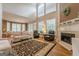 Bright and airy living room features a fireplace, tall windows, and comfortable seating at 7415 Northampton Ct, Cumming, GA 30040