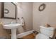 Charming powder room featuring a pedestal sink, decorative mirror, and tasteful accents at 7415 Northampton Ct, Cumming, GA 30040