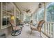 Inviting screened porch featuring comfortable seating, ceiling fan, and serene views of the surrounding landscape at 7415 Northampton Ct, Cumming, GA 30040