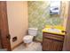 Small bathroom features floral wallpaper, toilet, vanity, and a mirror at 204 Mitchell Rd, Fayetteville, GA 30214