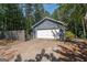 Detached garage with white door situated beside a wooden fence with a concrete driveway at 204 Mitchell Rd, Fayetteville, GA 30214