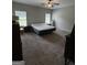 Comfortable bedroom with ceiling fan, plush carpet, and natural light at 4529 Jersey Covington Rd, Covington, GA 30014