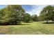 View of a large, grassy lot surrounded by mature trees at 4529 Jersey Covington Rd, Covington, GA 30014