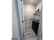Modern laundry room with white washer and dryer, storage shelving, and neutral paint at 4529 Jersey Covington Rd, Covington, GA 30014