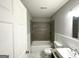 Bathroom featuring a tiled shower/tub, white wainscotting, and neutral gray walls at 3729 Glenwood Rd, Decatur, GA 30032