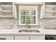 Sunlit kitchen sink with white subway tile, quartz countertop, and a view to the backyard at 2695 Peeler Rd, Doraville, GA 30360