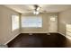 A bright living room with dark hardwood floors, a ceiling fan, and large windows offering natural light at 4250 Timber Valley Ct, Decatur, GA 30032