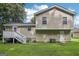 A tan siding home boasts a well-kept lawn and a charming deck with stairs in the backyard at 3980 Carlton Cove Ct, Loganville, GA 30052