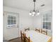 Bright dining area with a white chandelier, wooden table and chairs at 3980 Carlton Cove Ct, Loganville, GA 30052