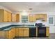 Functional kitchen with laminate countertops, wood cabinets, and black appliances at 3980 Carlton Cove Ct, Loganville, GA 30052