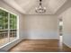 Bright dining room featuring hardwood floors, modern lighting, and a large window with treed views at 9591 Teal Ter, Jonesboro, GA 30238