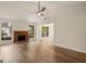 Open living room with a fireplace, wood-look floors, and views into the dining area at 9591 Teal Ter, Jonesboro, GA 30238