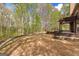 Expansive backyard featuring a stone patio, pergola, and wooded surroundings at 368 Yellowwood Dr, Sharpsburg, GA 30277