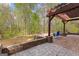 Inviting backyard featuring a pergola, fire pit, and patio, creating an ideal outdoor entertaining space at 368 Yellowwood Dr, Sharpsburg, GA 30277