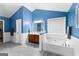 Bathroom features blue walls, white trim, a soaking tub, and a single sink vanity at 368 Yellowwood Dr, Sharpsburg, GA 30277