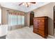 Bedroom features neutral paint, beige carpeting, and a large window with blinds and curtains at 368 Yellowwood Dr, Sharpsburg, GA 30277