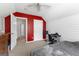 Cozy bedroom featuring a ceiling fan, red accent wall, and desk area, offering a comfortable and functional space at 368 Yellowwood Dr, Sharpsburg, GA 30277