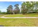Expansive community green space with walking paths, mature trees, and a playground in the distance at 368 Yellowwood Dr, Sharpsburg, GA 30277