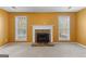 Bright living room features a stone fireplace flanked by windows, offering a cozy ambiance at 368 Yellowwood Dr, Sharpsburg, GA 30277