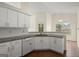 Well-lit kitchen with white cabinets, granite countertops, and stainless steel dishwasher at 1416 Flanagan Mill Dr, Auburn, GA 30011