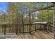 A rustic wooden deck overlooks a lush, green backyard with mature trees at 6064 Oak Hill Dr, Austell, GA 30168
