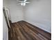 Bedroom with wood-look flooring, ceiling fan, and adjacent bathroom at 240 Carsons Cv, Mcdonough, GA 30253