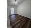 Bright bedroom with dark hardwood floors, white walls, ceiling fan and window at 240 Carsons Cv, Mcdonough, GA 30253