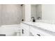 Modern bathroom featuring white cabinetry, a granite countertop, and a tiled shower and tub at 3413 Arabian Farm Ln, Dacula, GA 30019