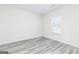 Bright bedroom with sleek, grey wood-look floors, white trim, and a large window at 3413 Arabian Farm Ln, Dacula, GA 30019