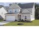 Charming two-story home with a brick and siding facade, attached garage, and well-manicured lawn at 3413 Arabian Farm Ln, Dacula, GA 30019