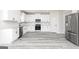 Kitchen showcases white cabinetry, stainless steel appliances, granite countertops, and modern gray wood-look floors at 3413 Arabian Farm Ln, Dacula, GA 30019