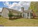 Well-maintained backyard featuring a lush lawn, mature trees, and an enclosed sunroom at 1010 Pinehurst Dr, Peachtree City, GA 30269