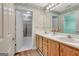 Charming bathroom featuring a double vanity, floral wallpaper, and a walk-in shower with glass doors at 1010 Pinehurst Dr, Peachtree City, GA 30269