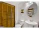Bright bathroom featuring a round mirror, pedestal sink, and wood-paneled closet doors at 12435 Hamilton Rd # 536/- Ac, Chattahoochee Hills, GA 30268