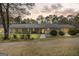 Exterior shot of a ranch-style home with a covered porch, showcasing a warm ambiance at twilight at 12435 Hamilton Rd # 536/- Ac, Chattahoochee Hills, GA 30268