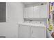 Functional laundry room with washer, dryer and ample overhead storage at 12435 Hamilton Rd # 536/- Ac, Chattahoochee Hills, GA 30268