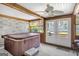 Enclosed sunroom with a hot tub, brick accents, and natural light through the surrounding windows at 12435 Hamilton Rd # 536/- Ac, Chattahoochee Hills, GA 30268