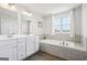 This bathroom offers a double sink vanity and a large soaking tub, perfect for unwinding after a long day at 864 Maduro Way, Mcdonough, GA 30253