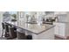 Kitchen island offering seating with a granite countertop and stainless steel sink at 864 Maduro Way, Mcdonough, GA 30253