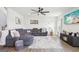 Cozy living room with large sectional, mounted TV, hardwood floors, modern ceiling fan and plenty of natural light at 864 Maduro Way, Mcdonough, GA 30253