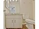 Bathroom with a granite countertop vanity, framed mirror, and white toilet at 212 Bella Rosa, Peachtree City, GA 30269