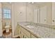 Well-lit bathroom featuring granite countertops and a large mirror at 212 Bella Rosa, Peachtree City, GA 30269