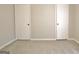 A modest bedroom with neutral-toned walls, carpet, and two white doors at 212 Bella Rosa, Peachtree City, GA 30269