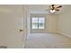 Bright bedroom featuring neutral carpet, a ceiling fan, and a window that offers ample natural light at 212 Bella Rosa, Peachtree City, GA 30269