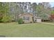Attractive home surrounded by mature trees and green grass at 212 Bella Rosa, Peachtree City, GA 30269