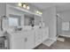 Bathroom showcasing double sink vanity with framed mirror, white cabinets, and walk-in shower at 176 Butler Rd, Brooks, GA 30205